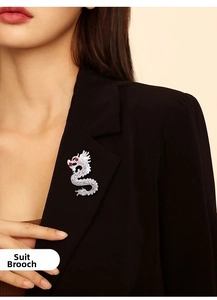 Broche dragon argentée avec cristaux et yeux en pierres rouges sur revers de costume noir
