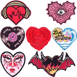 Close-up of seven assorted heart-shaped embroidered patches with creative punk motifs