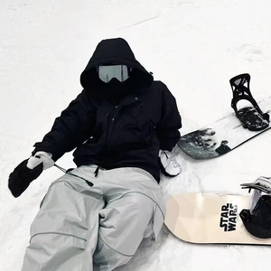 Outdoor skiing set featuring black jacket, grey pants, gloves, and silver goggles in snow