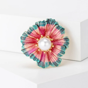 Elegant floral brooch with pink enamel petals and a central white pearl on white blocks