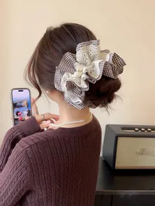Close-up of houndstooth and lace scrunchie worn in hair with a lifestyle background