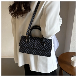 Blue crossbody handbag with geometric pattern on model wearing white blazer