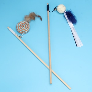 Detail of wooden cat wand with colorful feathers, woven balls and metal bells on blue