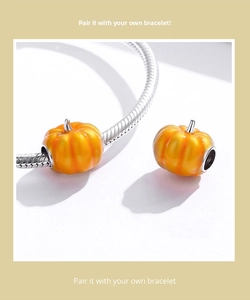Detail of orange enamel pumpkin charm on silver snake chain bracelet for Halloween jewelry