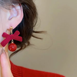 Vue détaillée des boucles d'oreilles nœud en velours rouge portées par un mannequin