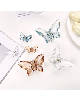 Detailed flat lay of transparent butterfly hair claws in various sizes and colors