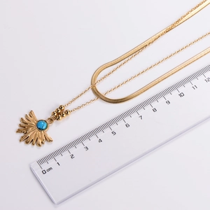 Detailed view of vintage gold double-layer necklace with sunburst turquoise pendant and ruler