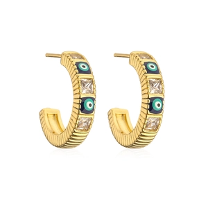 Detail of gold-plated eye earrings featuring blue enamel and clear square cubic zirconia