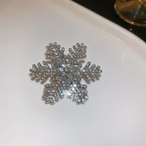Close-up of snowflake hair clip with silver base and sparkling rhinestones