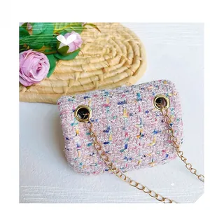 Draufsicht einer rosa Tweed-Miniteasche mit Goldkette und Blumendekoration