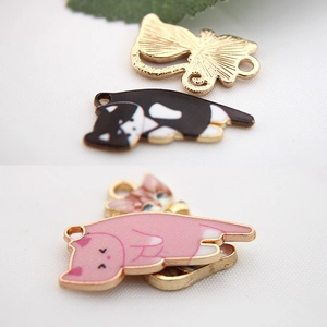 Macro detail of cat shaped alloy pendants showing colorful enamel finish and gold plating