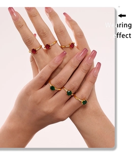 Close-up of model wearing emerald and ruby gold rings with refined zircon accents
