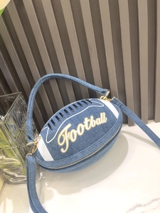 Close-up of denim football handbag with white stripes and golden zipper hardware