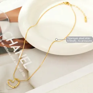 Minimalist gold titanium steel necklace featuring a hollow heart pendant on snake chain