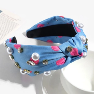 Détail d'un serre-tête bleu noué à pois avec perles fantaisie et strass brillants