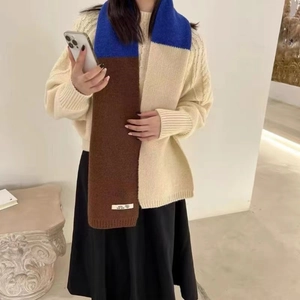 Détail de l'étiquette en laine sur une écharpe en maille bicolore bleu marron et beige