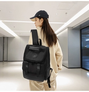 Rear view of a black nylon backpack with double PU leather straps and drawstring closure