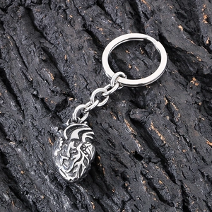Gothic anatomical heart keychain in vintage silver finish on black wood background