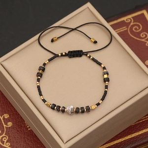 Handmade Bohemian beaded bracelet with natural stone and golden accents on a jewelry box