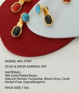 Detail view of retro gold earrings with oval gemstones in red, turquoise, and black