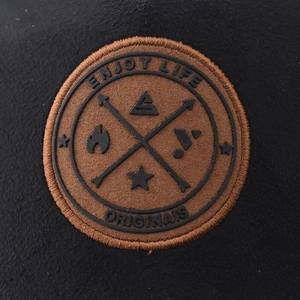 Detailed macro of the Enjoy Life embroidered patch on a black baseball cap surface