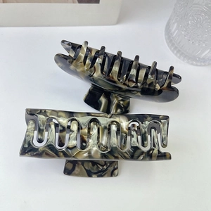Detail shot of large square acetate hair claws with premium forest green marble pattern