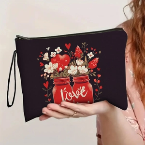 Elegant black heart makeup bag with floral print and wristlet strap held by a model