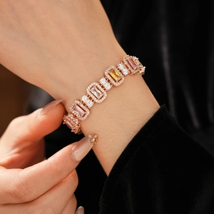 Close-up of rose gold bracelet with colorful rectangular zircons worn on wrist