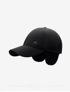 Detail of black winter baseball cap with ear flaps and side mountain metal badge