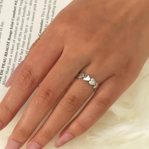 Elegante anello a cuore traforato in argento mostrato sulla mano con stile raffinato