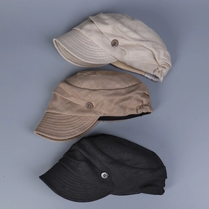 Detailed view of linen baker boy hats in beige, coffee and black with button detail