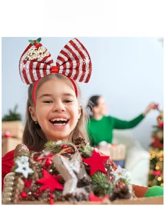 Détail du serre-tête de Noël avec un grand nœud à paillettes rouges et blanches et Feliz Navidad