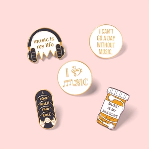 Set of music-themed enamel pins featuring headphones and music is my life lettering
