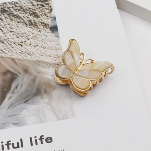 Detailed close-up of a vintage double-layer butterfly hair claw with marble texture