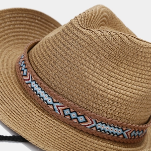 Close-up of bohemian straw sun hat featuring a colorful geometric diamond woven band