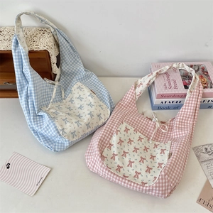 Détail de sacs fourre-tout à carreaux avec poches à nœud floral et cordon de serrage