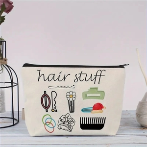 Detail der beigen Segeltuch-Kosmetiktasche mit Hair Stuff-Aufdruck auf hellem Holztisch