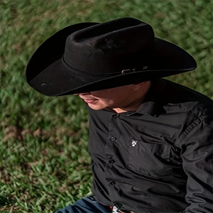 Detailed view of a black wool felt western cowboy hat worn with a black shirt outdoors