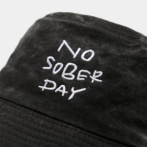 Black washed cotton bucket hat with white embroidery detail for outdoor sun protection