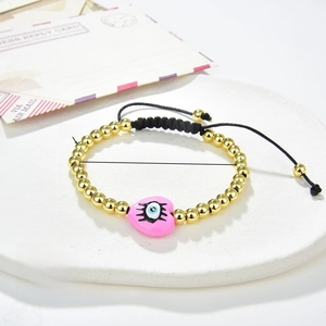 Detail of beaded evil eye bracelet with pink heart enamel on a stone display