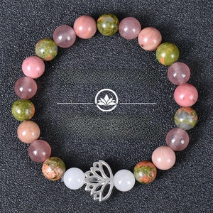 Detail of natural stone yoga bracelet featuring multicolored beads and lotus charm