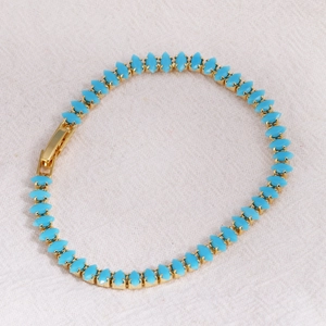 Detail of marquise-cut sky blue zircon stones set in a gold-plated tennis chain bracelet