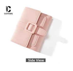Vista laterale di un portafoglio minimalista rosa con trama litchi e fibbia in resina