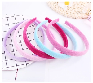 Detail showing a set of five soft velvet headbands in various pastel shades for women