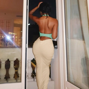 Close-up of backless halter top and beige bodycon maxi skirt on a model at night