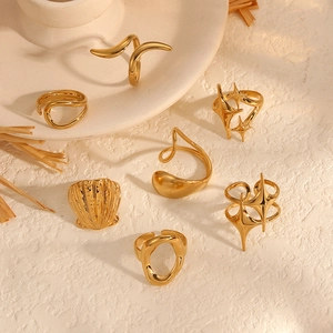 Set of 7 gold geometric stainless steel rings with abstract wave and star patterns