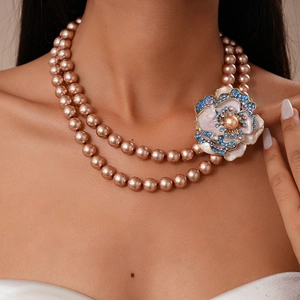 Détail d'un collier de perles double couche vintage avec pendentif fleur serti de cristaux