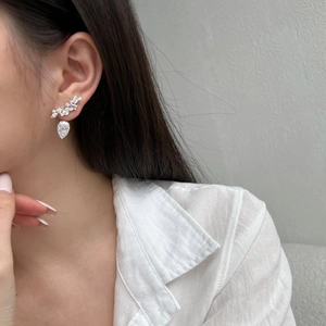 Macro shot of S925 silver pear-cut zircon teardrop drop earrings on female model