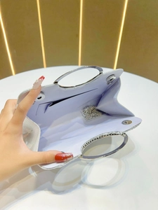 Silver pleated evening clutch bag with round metal handle and detachable chain strap
