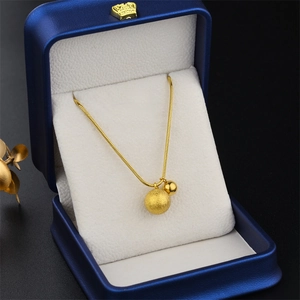 Gold snake chain necklace with matte and polished beads in a blue jewelry box